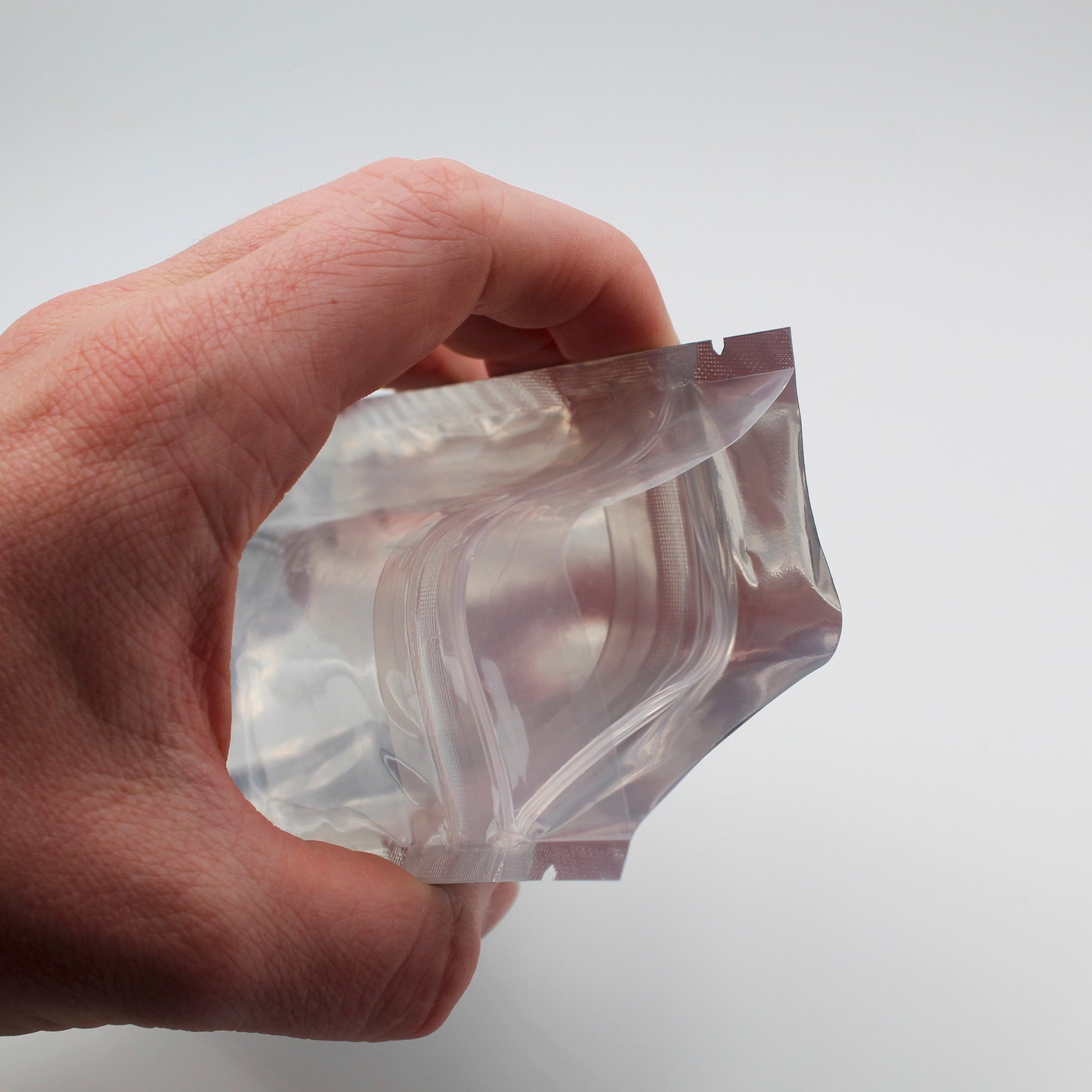 1/8oz (3.5g) White/Clear Child-Resistant GriploK Vista Mylar Dispensary Bag with Film Above Zipper (Opened in Hand)