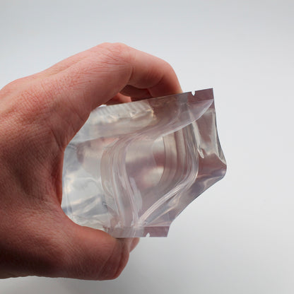 1/8oz (3.5g) White/Clear Child-Resistant GriploK Vista Mylar Dispensary Bag with Film Above Zipper (Opened in Hand)